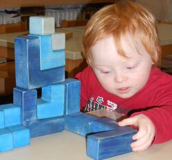 Integratives Kind spielt mit Bausteinen
