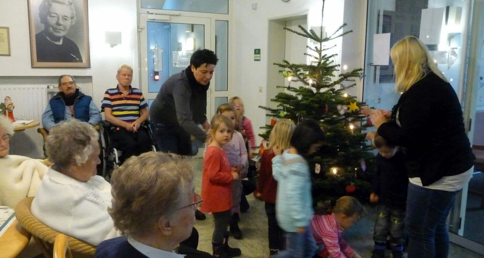 Kita Kinder schmücken den Weihnachtsbaum für Senioren