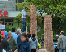 Ein Jugendlicher baut an einem Turm aus einzelnen Holzsteinen