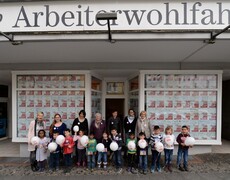 Menschengruppe vor Schaufenster mit Plakaten gegen Rassismus