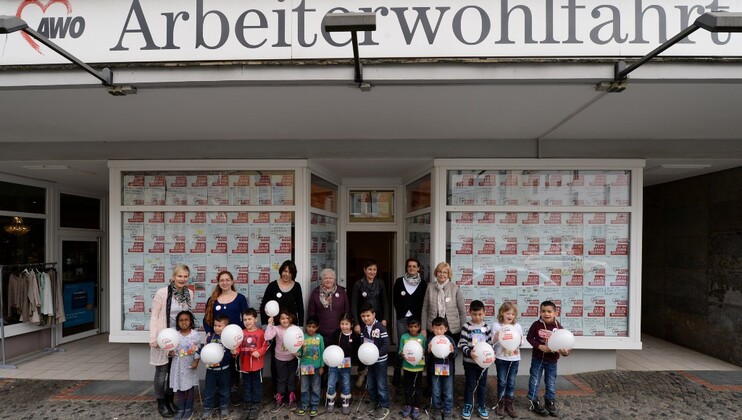 Menschengruppe vor Schaufenster mit Plakaten gegen Rassismus