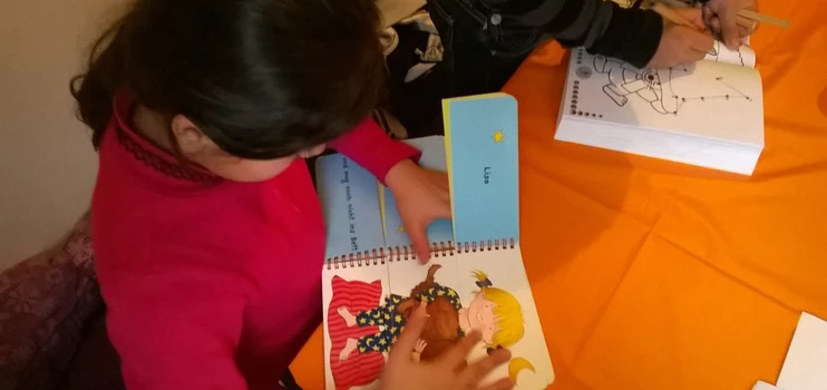 Ein Mädchen schaut ein Textbilderbuch an