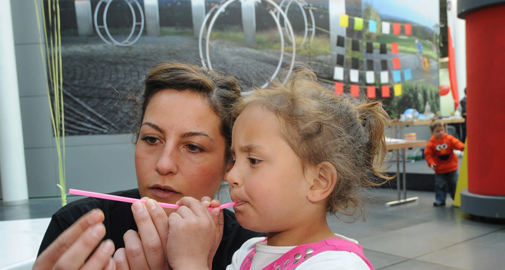 Mutter und Tochter experimentieren mit einem Strohhalm