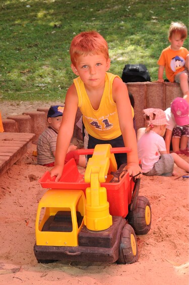 Junge mit Auto im Sandkasten