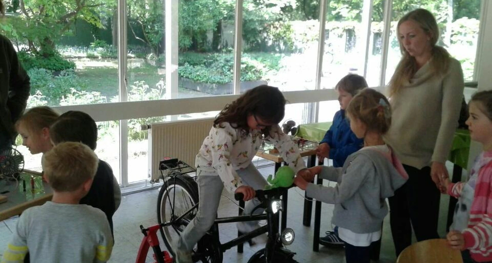 Ein Mädchen auf einem Fahrrad erzeugt Energie - Kinder der Kita Braunsberger Straße nehmen an einem Umweltworkshop teil