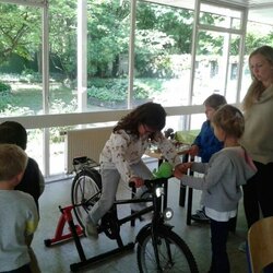 Ein Mädchen auf einem Fahrrad erzeugt Energie - Kinder der Kita Braunsberger Straße nehmen an einem Umweltworkshop teil