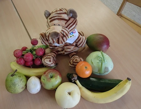Stofftiger zwischen Früchten und Gemüse
