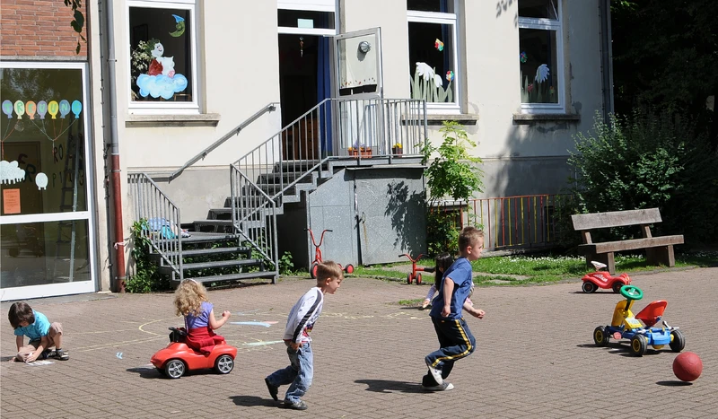 Kinder auf dem Gelände vor der Einrichtung