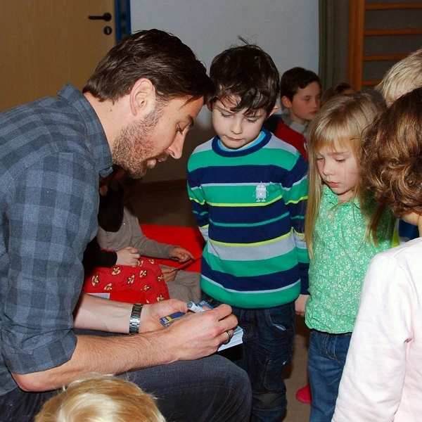 VFL-Spieler Heiko Butscher gibt den Kindern Autogramme