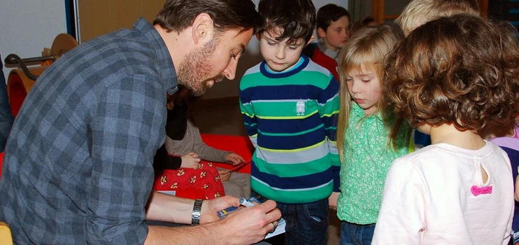 VFL-Spieler Heiko Butscher gibt den Kindern Autogramme
