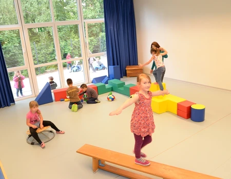 Kinder im Bewegungsraum - Mädchen balanciert