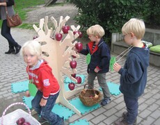 Kinder schmücken den Apfelbaum