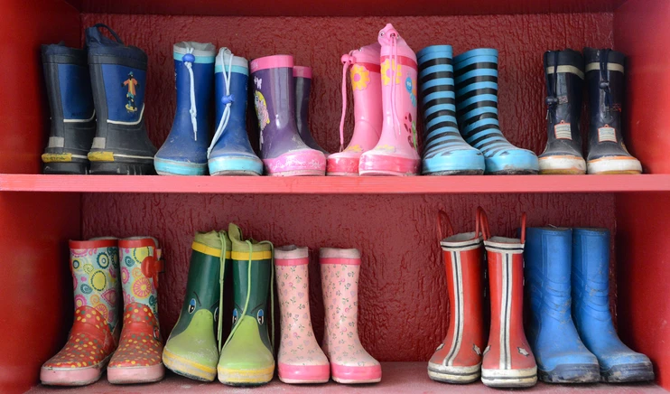 Bunte Kindergummistiefel im Regal