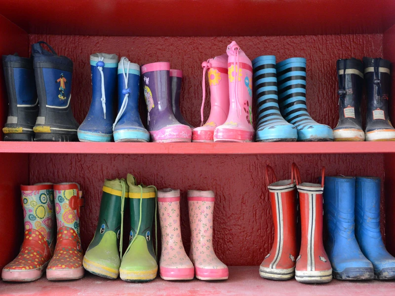 Bunte Kindergummistiefel im Regal