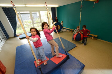 Kinder schaukeln in der Sporthalle