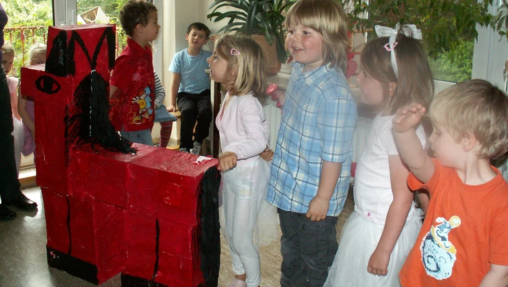 Kinder mit einem roten Pferd aus Pappe
