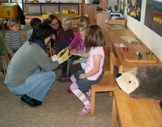 Kinder und Erzieherin mit einem Igel
