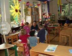 Erzieherin und Kinder bei der Gruppenarbeit