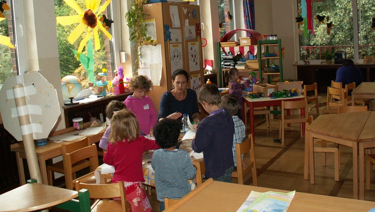 Erzieherin und Kinder bei der Gruppenarbeit