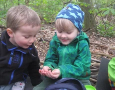 Zwei Kinder im Wald betrachten ein Fundstück