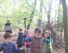 Jungen spielen im Wald an einer selbst gebauten Schaukel