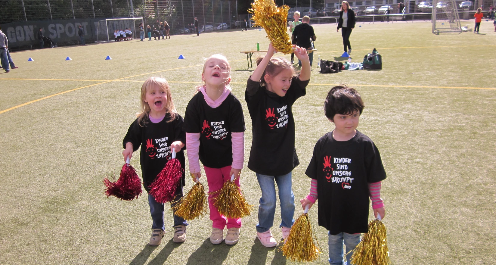 Vier Mädchen mit Cheerleaderpuscheln
