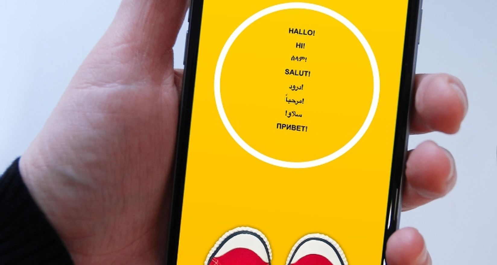 Eine Hand mit Handy darin liegend. Das Display zeigt die Start-Seite der APP YOUNGREFUGEES_NRW