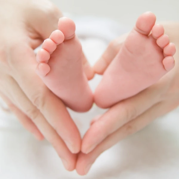 Babyfüße in den Händen der Mutter