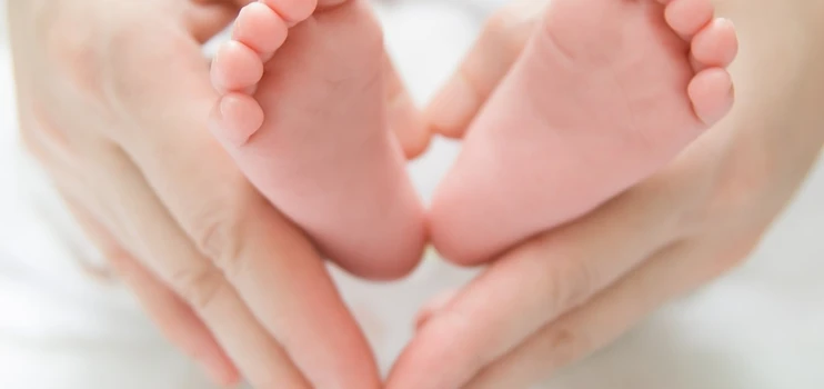 Babyfüße in den Händen der Mutter