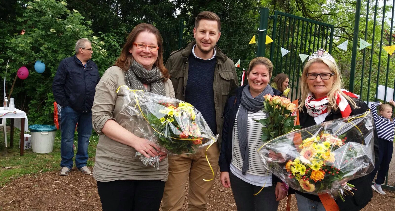 Mitarbeiter des Fachbereichs OGS im Außengelände der Horstschule. Zwei Frauen mit Blumensträußen.