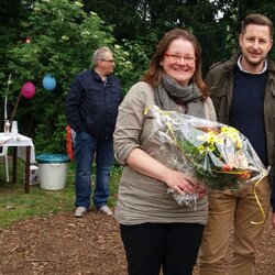 Mitarbeiter des Fachbereichs OGS im Außengelände der Horstschule. Zwei Frauen mit Blumensträußen.