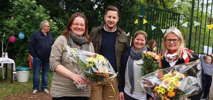 Mitarbeiter des Fachbereichs OGS im Außengelände der Horstschule. Zwei Frauen mit Blumensträußen.
