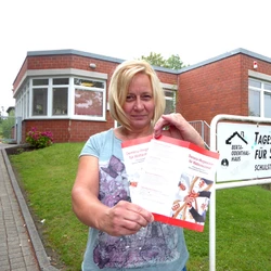 Die Leiterin der AWO Tagespflege hält den neuen Flyer des Demenz-Netzwerkes in die Kamera