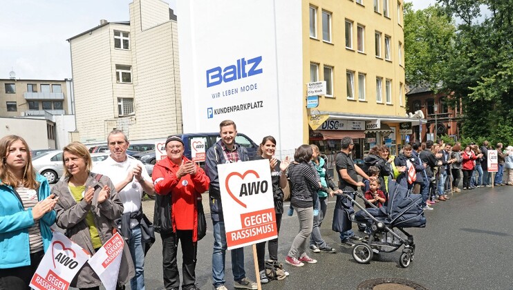 Menschenkette mit Schildern "AWO gegen Rassismus"