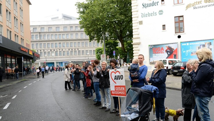 Menschenkette mit Schildern "AWO gegen Rassismus"