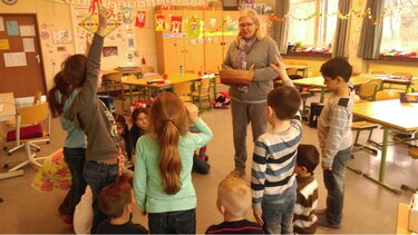 Kindergruppe mit Lehrerin im Klassenraum