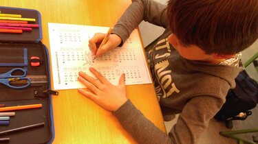 Ein Junge rechnet mit einem Zahlenbogen