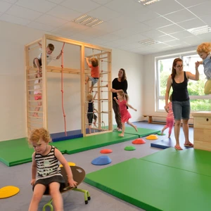Kindergruppe mit ihren Erzeiherinnen im Bewegungsraum