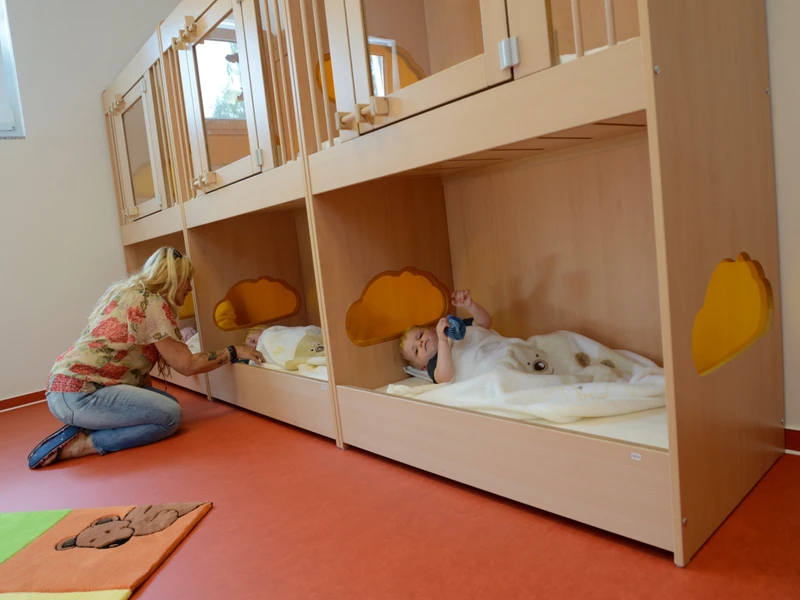 Kinder in Kinderbettchen im Schlafraum