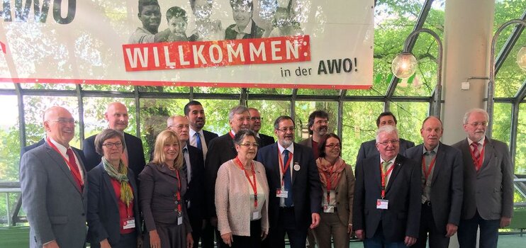 Neuer Vorstand: Gruppenaufnahme von Männern und Frauen unter einem Banner mit der Aufschrift: Willkommen in der AWO