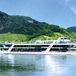 Schiff auf dem Wasser, im Hintergrund grüne Hügel