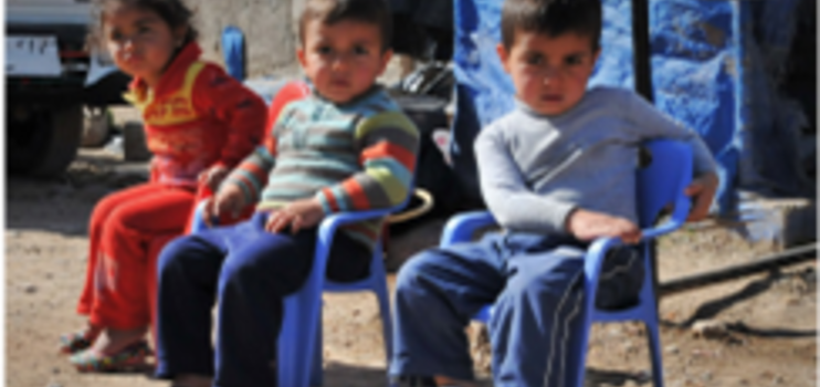 Kinder auf kleinen Stühlen vor der Unterkunft