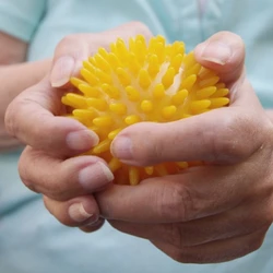 Nahaufnahme der Hände einer Frau die einen gelben Massageball hält
