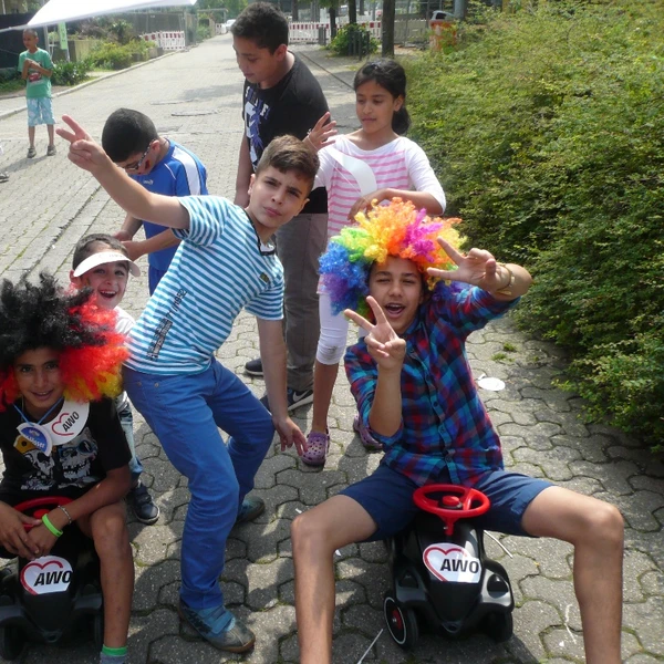 7 Kinder in der Hustadt, 2 mit Bobbycars und bunten Perücken