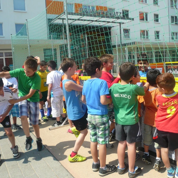 Kinder in der Hustadt drängeln und toben an der Streetsoccer-Absperrung